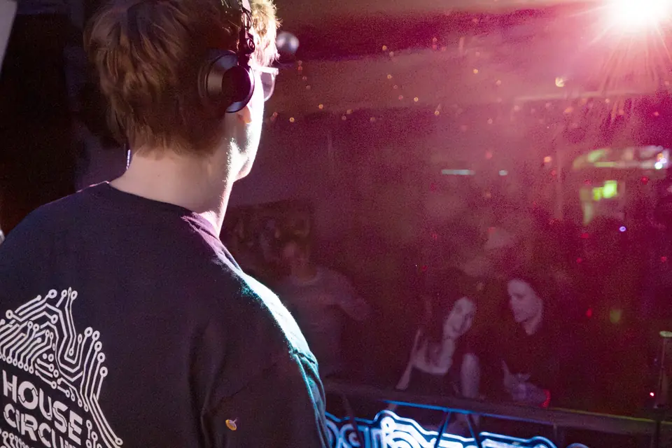 The DJ in a House Circuit shirt, facing the crowd